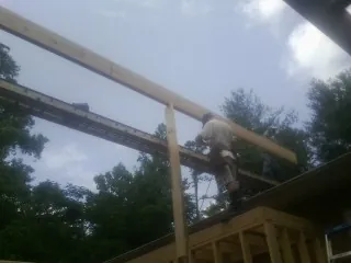 Carpenter setting a ridge beam over a new addition frame — Ice Dam Removal by Roofing Brothers in Narvon