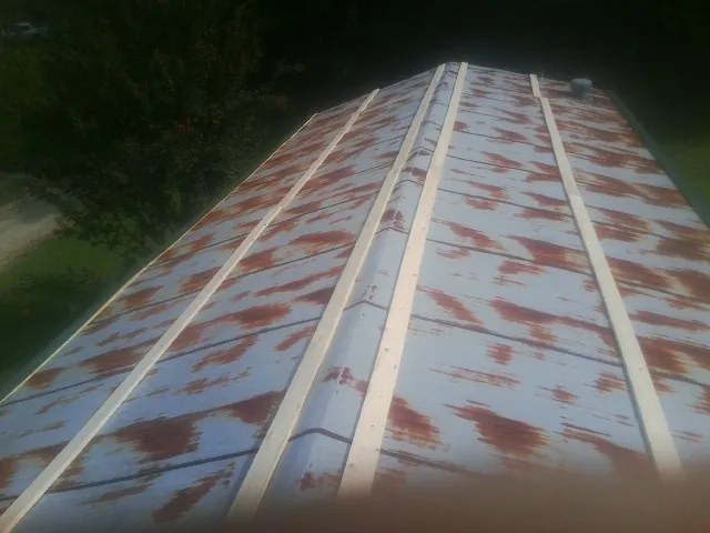 Rusted metal roof panels with new wood purlins before replacement — Storm Damage Roof Repair in Narvon by Roofing Brothers