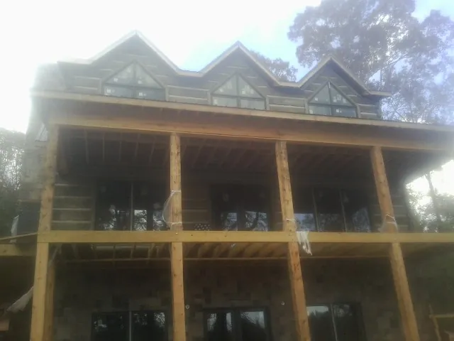 Dormers and porch framing on a large log home under construction — Roof Coating work by our crew in Narvon