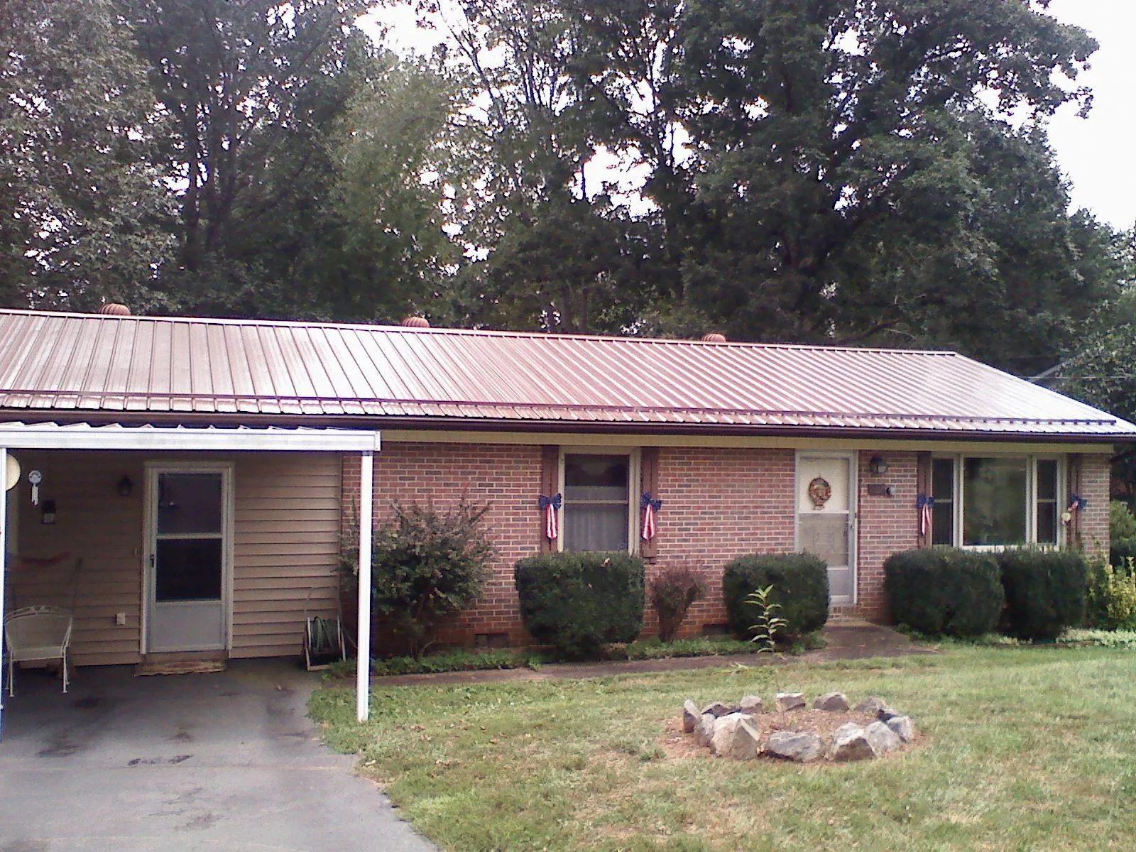 Bronze metal roof and carport on a brick ranch home — Roof Repair work by our crew in Narvon
